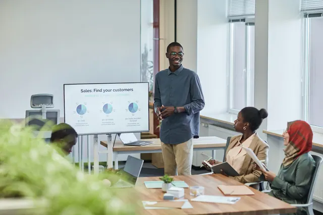 A diverse team having a corporate meeting with a sales presentation in a modern office setting. The practical 2027 guide to B2B sales funnels